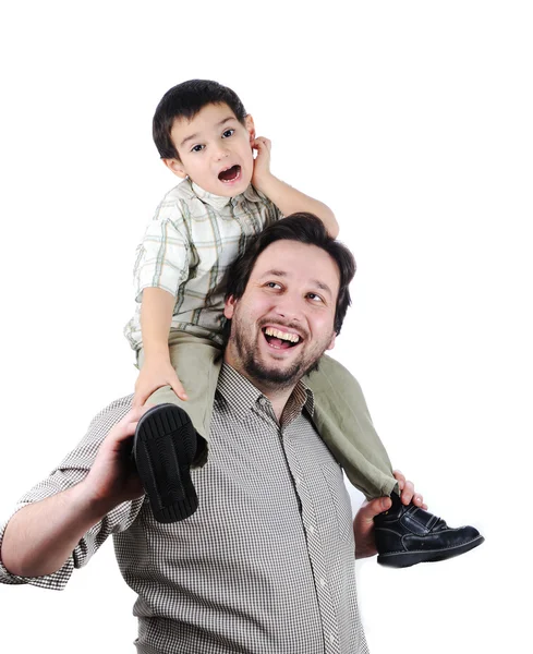 Man giving young boy piggyback ride outdoors smiling — Stock Photo, Image