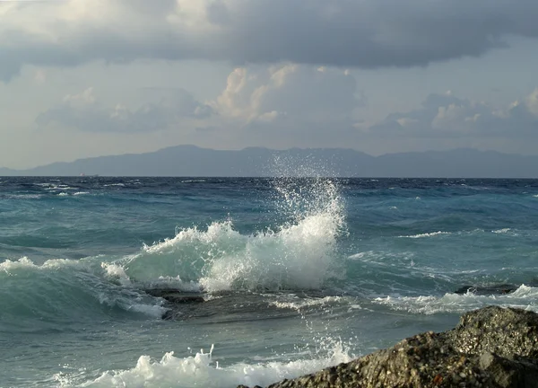Wave breaking against stones — Stock Photo, Image