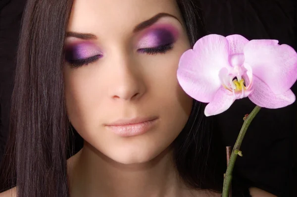 Brunette met orchideebloem — Stockfoto