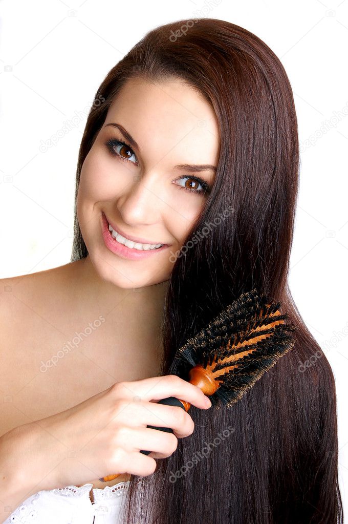 Young beautiful woman brushing her long