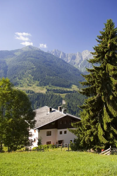Vale da montanha e casa em alpes austríacos no verão — Fotografia de Stock