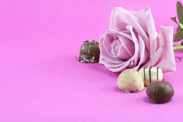Růžové růže a čokolády pozadí — Stock fotografie
