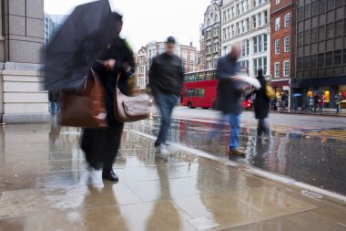 Busy london commuters in the pouring rai clipart