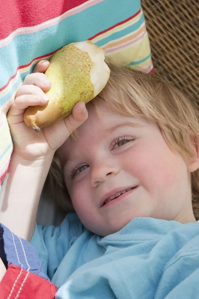 Liten pojke håller ett päron — Stockfoto