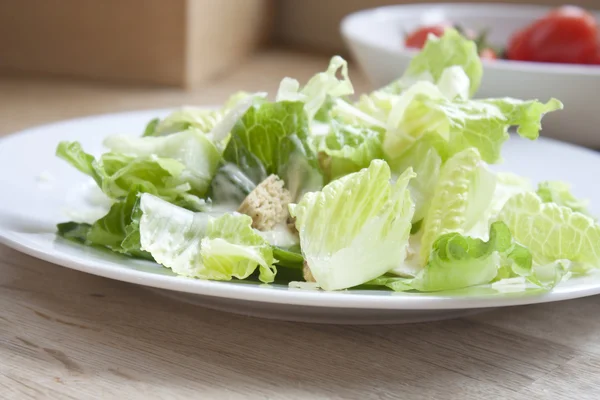 Caesar salade met tomaten in achtergrond — Stockfoto