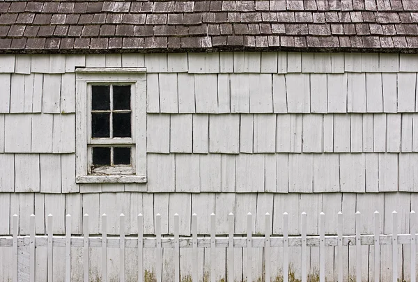 建物と古い、白いピケット フェンス — ストック写真