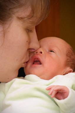 Mother kissing baby clipart