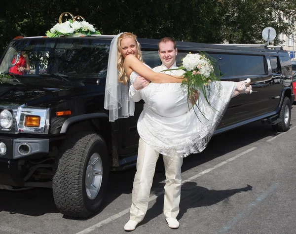Svatební pár poblíž limuzína — Stock fotografie