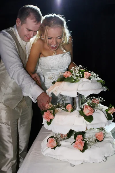 Glückliches Paar schneidet Hochzeitstorte an — Stockfoto
