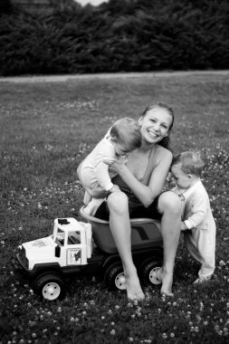 Twins with her mother in a car clipart