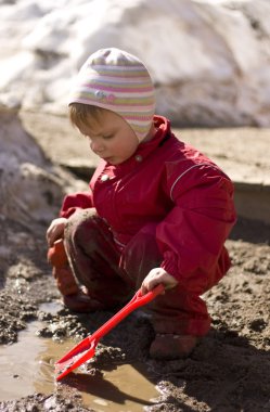 Child playing in the mud clipart