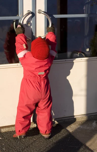Küçük bir çocuk büyük bir kapı açmaya çalışıyor — Stok fotoğraf
