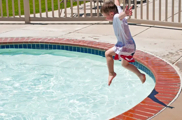 Liten pojke hoppar i poolen — Stockfoto