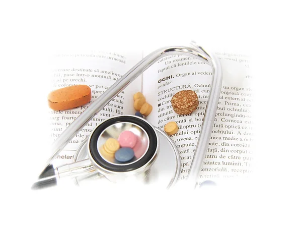 Estetoscopio y medicamentos en el libro médico — Foto de Stock