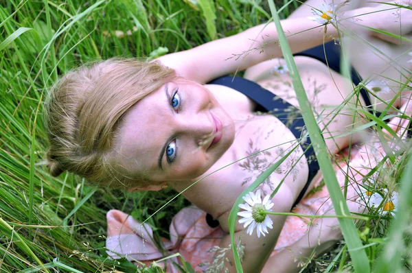 Красивая девушка с голубыми глазами в траве — стоковое фото