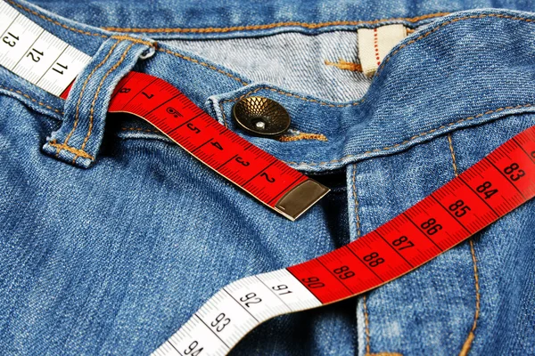 Calça jeans azul e fita métrica isolada — Fotografia de Stock