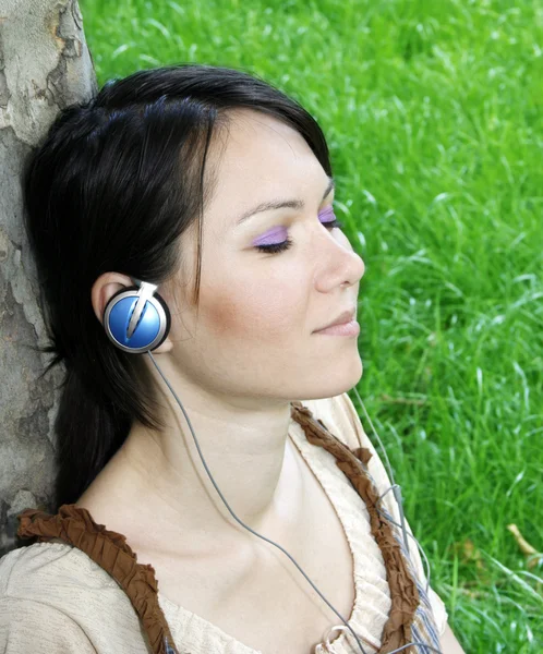 Ung kvinna lyssnar musik — Stockfoto