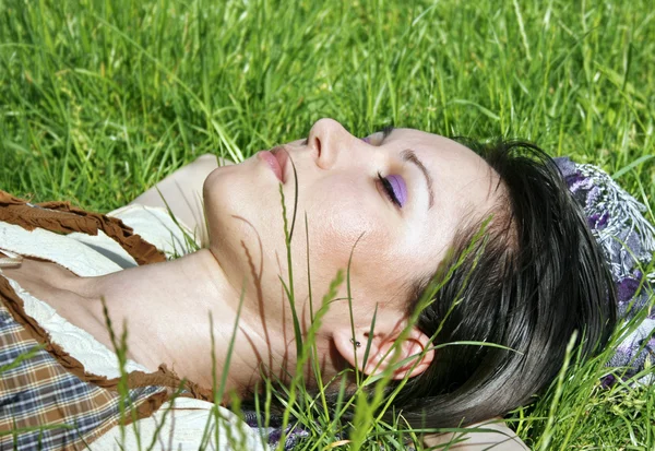 Jovem fêmea deitada na grama — Fotografia de Stock