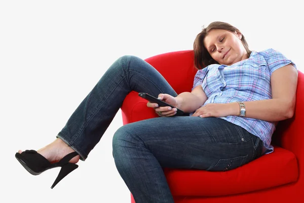 Girl on armchair with remote control — Stock Photo, Image