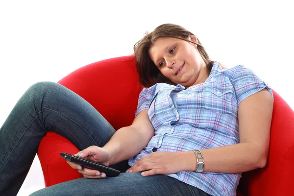 Girl on armchair with remote control — Stock Photo, Image