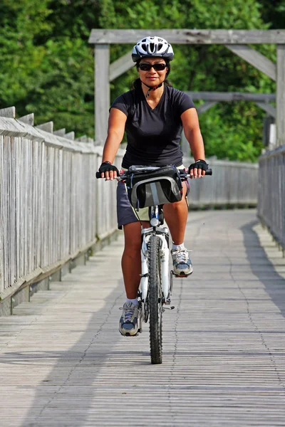 Köprüyü geçtikten adlı kadın bisikletçi — Stok fotoğraf