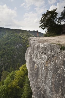 Woman standing on big rock clipart