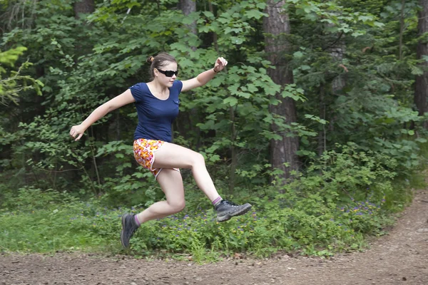Young woman jumping in the forest — Stock Photo, Image