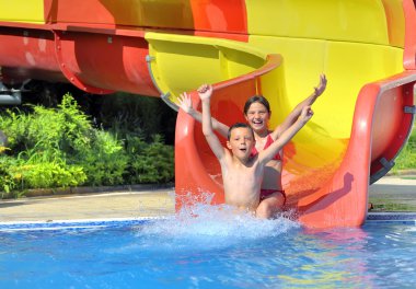 Children sliding down a water slide clipart