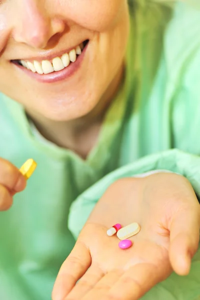 Женщина держит таблетки в руке — стоковое фото
