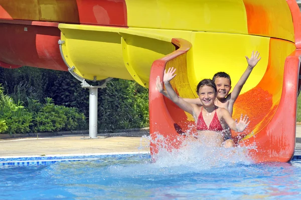 Children sliding down a water slide Royalty Free Stock Photos