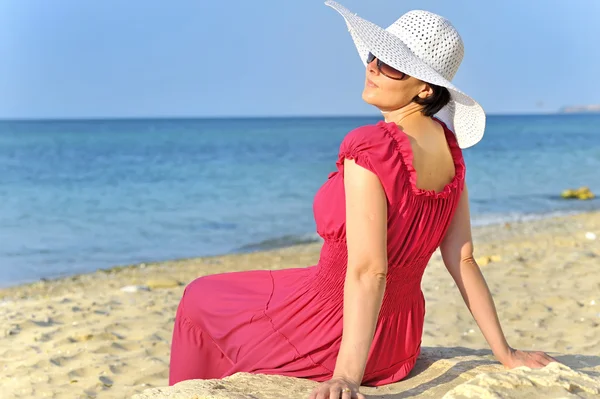 Portret piękne kobieta w czerwonej sukience na plaży — Zdjęcie stockowe