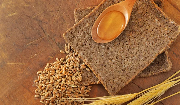 Plasterki chleb i łyżka miodu — Zdjęcie stockowe