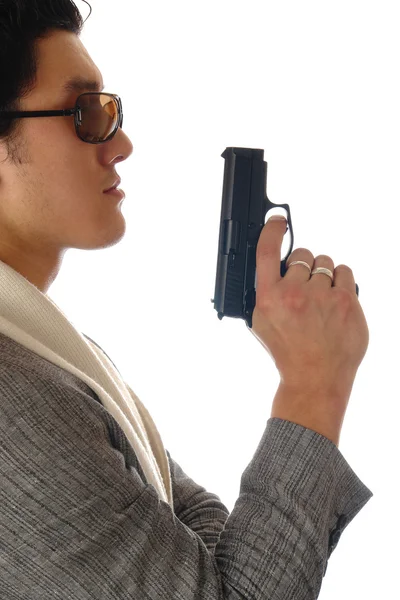 Azjatycki człowiek trzymając pistolet w ręku — Zdjęcie stockowe