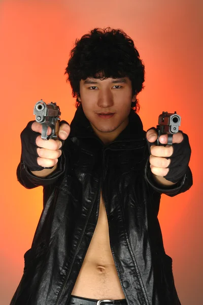 Azjatycki człowiek z dwóch broni w rękach — Zdjęcie stockowe