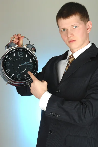 Jungunternehmer hält große Uhr in der Hand — Stockfoto