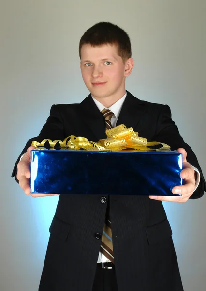 Junger glücklicher Geschäftsmann mit Geschenk — Stockfoto