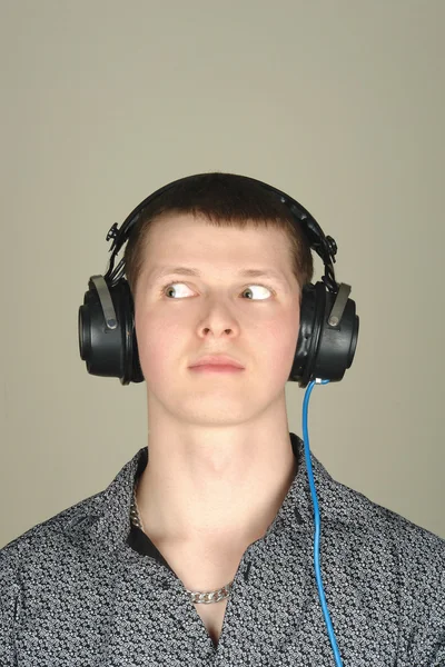 Молодий чоловік в навушниках дивиться — стокове фото