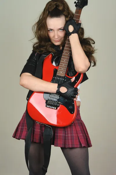 Mladá žena s červenou kytarou — Stock fotografie