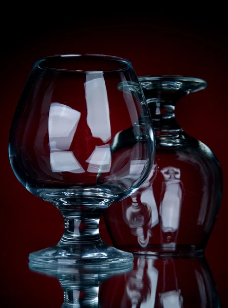 Close-up dois conhaque de vidro em um fundo vermelho — Fotografia de Stock