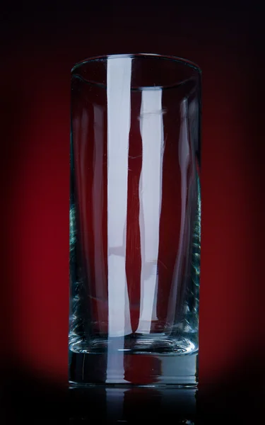 Leeres Glas auf rotem Bg — Stockfoto