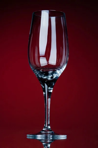 Leeres Weinglas auf rotem Grund — Stockfoto