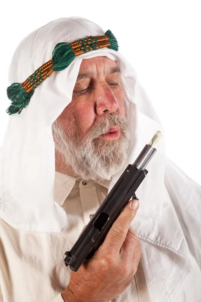 Arabiska man blåser på pengar stoppade i en pistol — Stockfoto