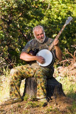 Older Man Playing the Banjo Outdoors clipart