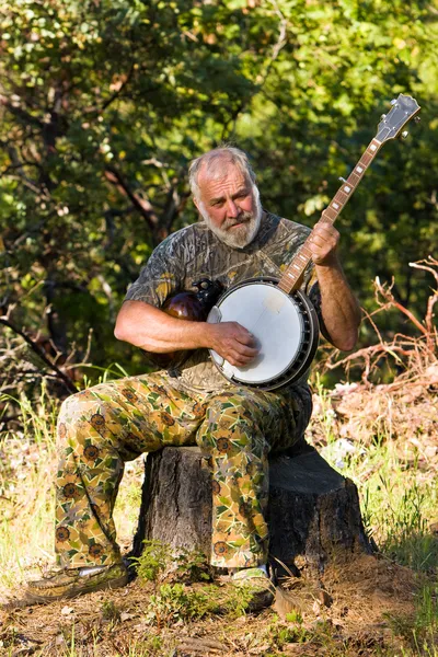 Взрослый человек играет на банджо на открытом воздухе — стоковое фото