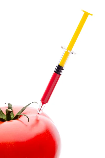 Ruisku Punaisen nesteen pistäminen vihreään tomaattiin — kuvapankkivalokuva