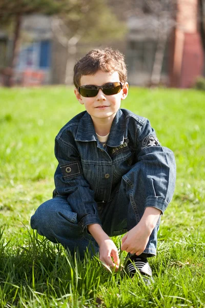 Δροσερό αγόρι σε ένα πεδίο χλόης — Φωτογραφία Αρχείου