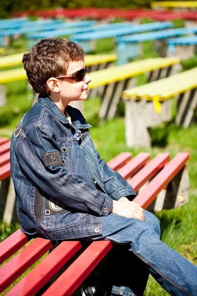 Cool boy sitting in a park — Stock Photo, Image