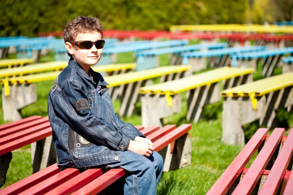 Крутий хлопчик сидить у парку — стокове фото