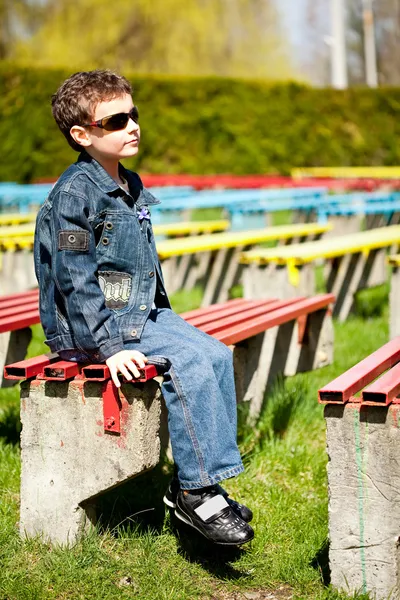 Крутой мальчик, сидящий в парке — стоковое фото