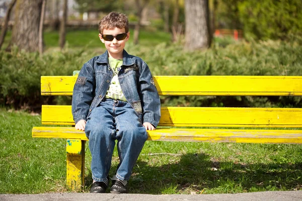 Cool gyerek ül a padon — Stock Fotó